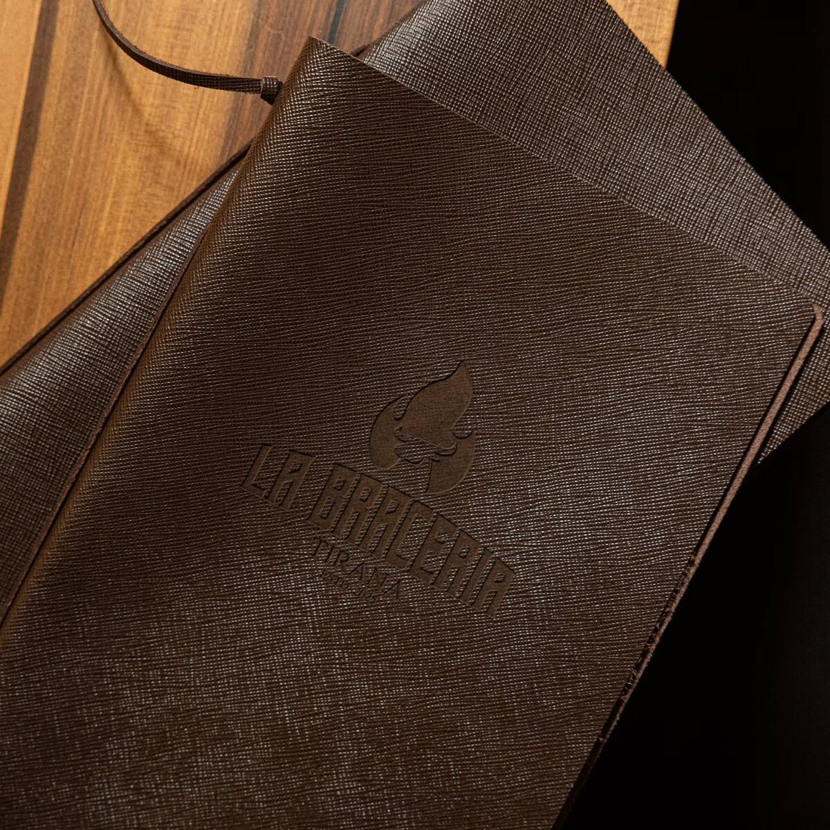 Black textured menu cover with embossed restaurant logo