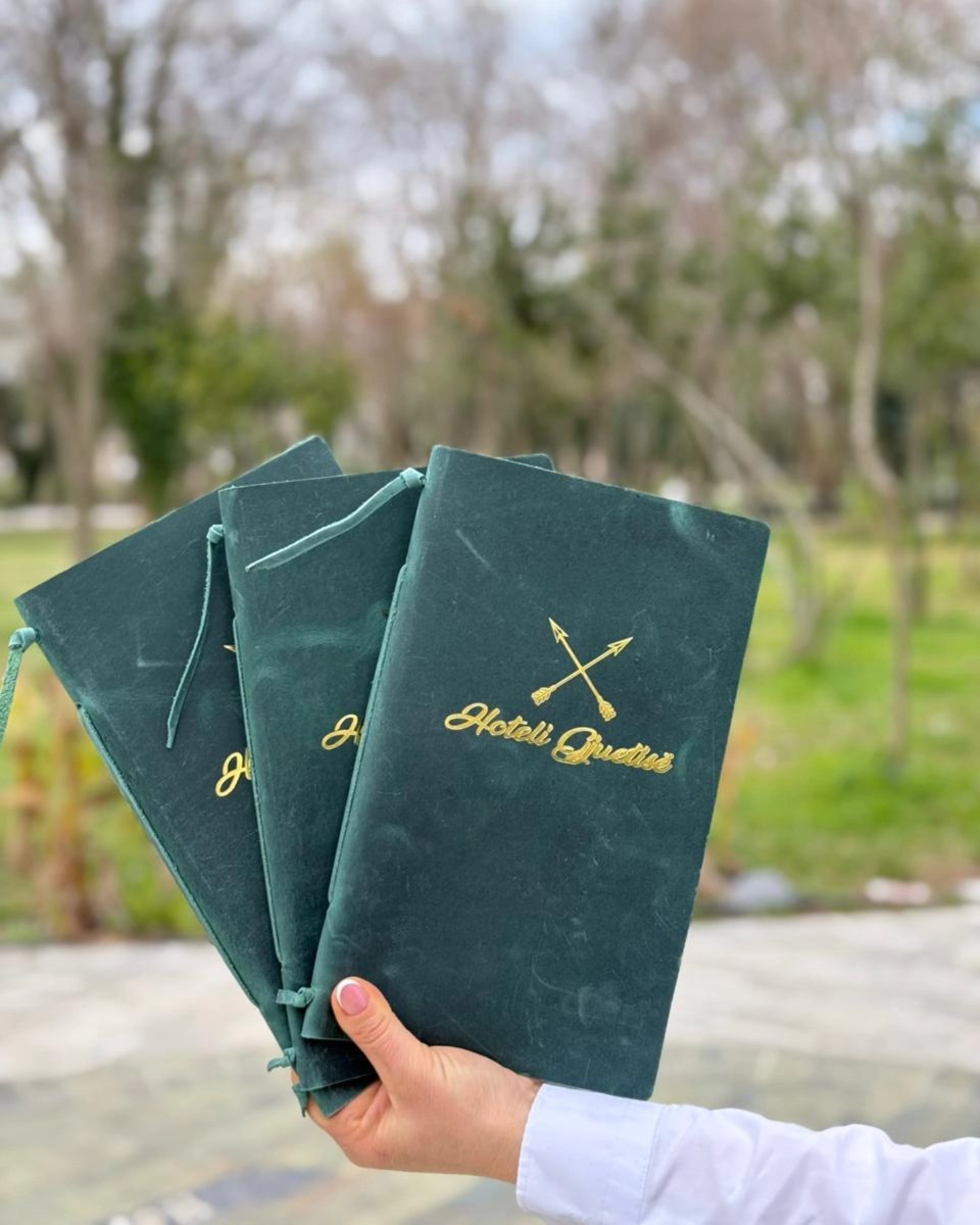 Green menu covers with gold restaurant logos